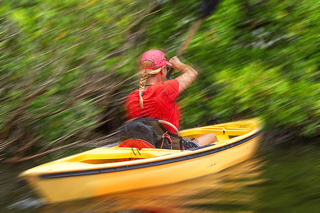 年轻女子在Everglades国家公园用运动模糊效果的皮艇图片