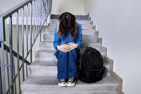 坐在台阶上的悲伤沮丧的年轻女士背包地面女性学校学生孤独大学女孩恐慌青少年图片