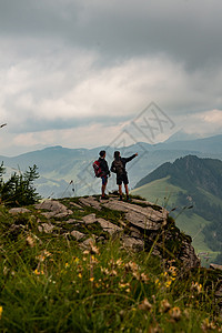 有两个人站在山悬悬崖上 其中一人指着远处的距离图片