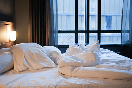 早上睡得乱七八糟的床 醒来后睡得乱成一团枕头毯子卧室亚麻织物窗户羽绒被房子白色床单图片