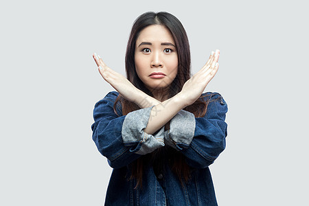 灰色背景的有感情的亚洲年轻女性蓝色黑发女孩女士手臂愤怒控制混血风格白色图片