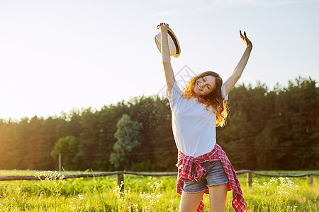 快乐的少女与帽子跳跃 欢乐的暑假性阳光喜悦女士晴天季节场地女孩草地快乐闲暇图片