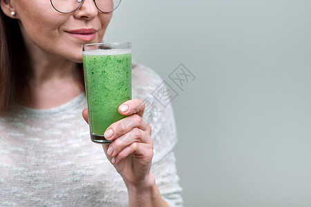 杯子紧贴 用绿色天然蔬菜冰沙水 由女人亲手喝薄荷饮料排毒玻璃女性早餐搅拌机损失活力饮食图片