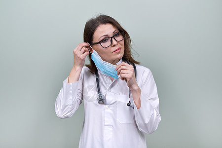 配有听诊器的女医生戴上医疗防护面具手术职业专家女士流感治疗师全科感染安全口罩图片