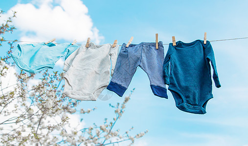 婴儿衣服在街上干燥 有选择的焦点蓝色衣绳别针衣夹母性横幅新生家务空气裤子图片