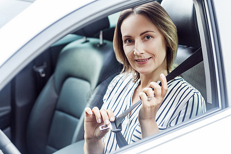 道路安全概念 漂亮的商业女商务人士在汽车上系安全带 并配上安全带图片