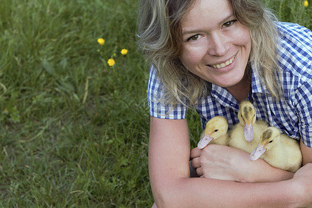 年轻女子在乡下手里握着一只小鸭子图片