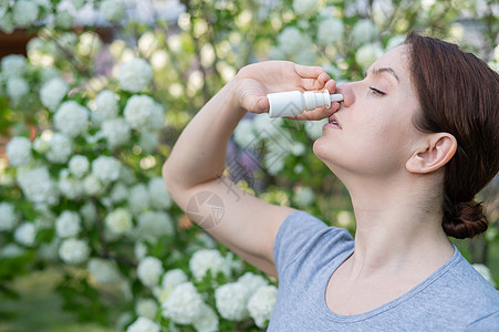 白种女人在公园散步时用鼻涕喷雾流感哮喘女性喷嚏瓶子支气管过敏治疗季节卫生图片