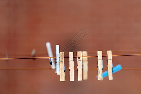 许多木制洗涤钉在一条线上 在阳光明媚的后院 旧木衣夹挂在晾衣绳上 用于在大自然的帮助下悬挂刚清洗过的衣物以风干的老式工具图片