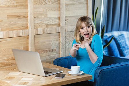 穿着蓝衬衫 坐着并从事计算机工作的情感劳动妇女指责商务女孩工人人士商业互联网笔记本手指业者图片