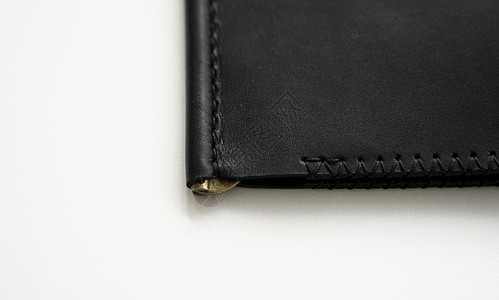 白色背景上空的经典黑色皮革手工钱夹钱包的详细信息 皮革配饰图片