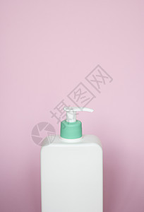 大型白色化妆塑料瓶 装有抽水泵泵和粉红色底部绿帽 含凝胶 润滑剂 奶油 洗发水 浴泡沫的液体容器图片