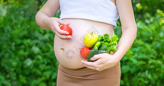 孕妇手里拿着蔬菜 有选择的专注点营养生活福利母性女孩家庭腹部肚子横幅怀孕图片