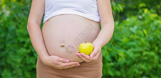 手里拿着苹果的孕妇 有选择地专注营养父母横幅卫生家庭女士母性生活产妇婴儿图片