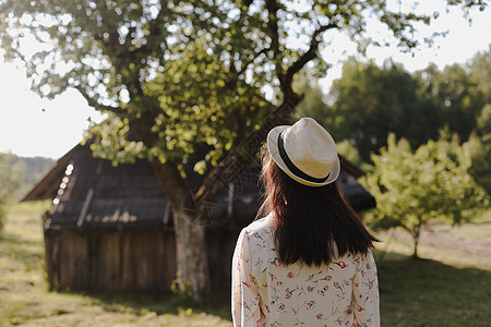 夏天在乡下穿草帽和漂亮裙子的年轻女子的浪漫肖像 笑声女性旅行村庄女孩阳光乡村凉帽稻草快乐黑发图片