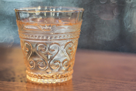 以美丽的古代威士忌为颜色的饮用水 在模糊的背景下用玻璃杯标本图片