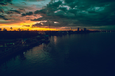 全景城市景色在日落时全景 泰国前方有大河流 背景是云暴云景观日出地标港口热带市中心雨季鸟瞰图场景建筑图片