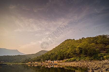 热带湖泊和山丘全景 泰国苏霍泰湖旁边的小型竹子传统小屋舍图片