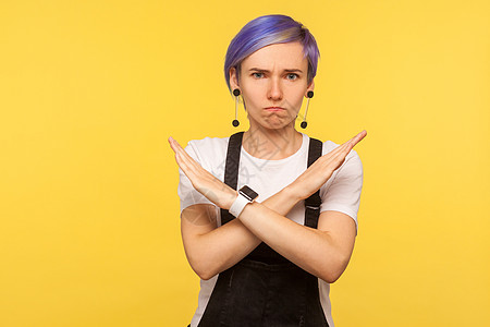 黄色背景的情绪时髦女人的肖像禁令紫色头发女士警告愤怒语言背带裤手势衰退图片