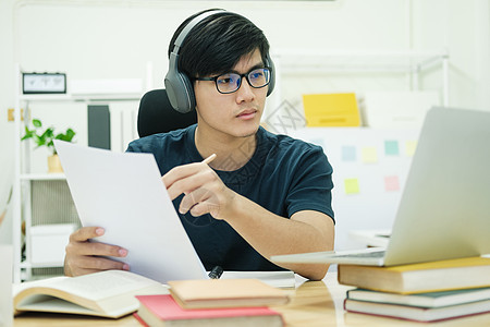 年轻人在家笔记本电脑前学习学院技术家庭作业研讨会电话网络工作学生大学培训图片