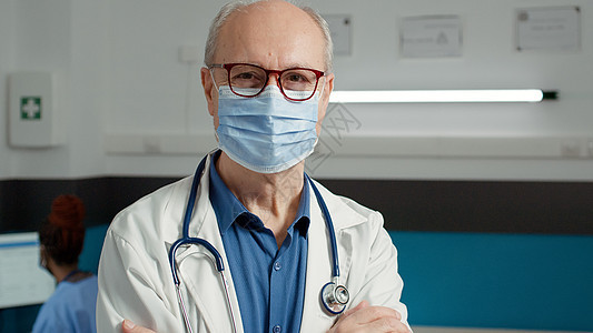 在保健系统工作时戴面罩的男医生的肖像;图片