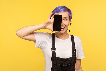 黄色背景的情绪时髦女人的肖像享受视频潮人紫色牛仔自由职业者眼睛服务屏幕女性图片