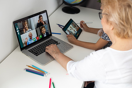 快乐的成熟祖母和可爱的小孙女在家里一起使用平板电脑 兴奋的中年妇女和可爱的孩子看着设备屏幕公寓网络连接朋友成人视频内容家庭社交游图片