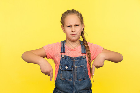 美丽的小女孩站在黄色背景的肖像画上 笑声控制手指女性手势责备牛仔警报教养命令孩子背景图片
