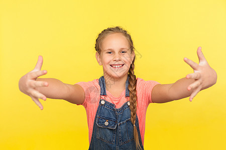 美丽的小女孩站在黄色背景的肖像画上 笑声表演幸福欢迎孩子女性乐趣拉伸情感成功童年图片