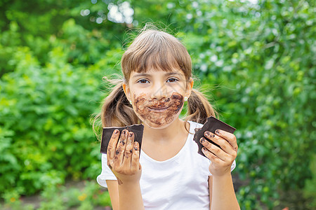 孩子吃巧克力棒 有选择的专注女性食物青年微笑饮食女孩幸福酒吧可可横幅图片