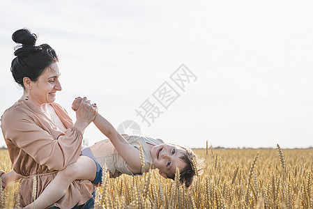 母亲和婴儿在小麦田上行走的幸福家庭男人父母自由场地女性儿子父亲农业喜悦小麦图片