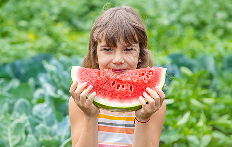 野餐上的孩子吃西瓜 有选择性的专注公园孩子们婴儿快乐食物营养女孩微笑赤脚童年图片