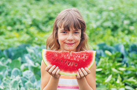 野餐上的孩子吃西瓜 有选择性的专注营养乐趣婴儿晴天女孩食物花园家庭横幅水果图片