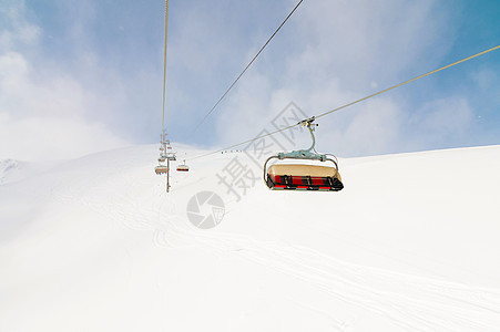 高山顶的露天升空 下坡滑雪 日落之日被雪田包围 天气好时滑雪度假村斜坡高山滑雪者升降椅运动开放高度滑雪板蓝色电缆天空图片