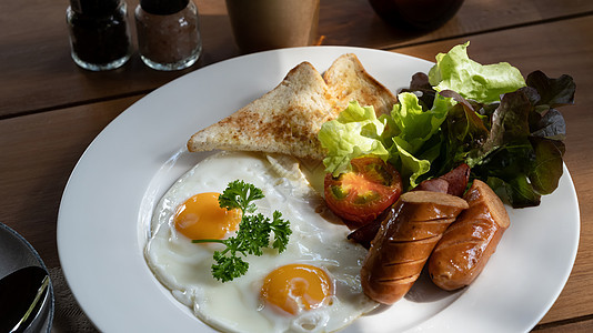 英语早餐 炸鸡蛋 培根 香肠 吐司和新鲜沙拉图片