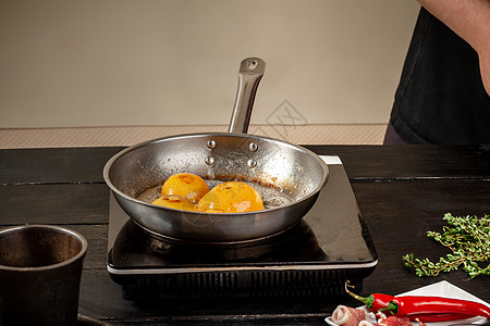 煎锅上的桃子 罐头果黄色桃子 黑木本底 板子树叶桌子水果收成食谱木板灰尘早餐厨师美味图片