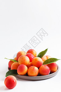 白色背景的盘子中的杏仁 复制空间红色叶子宏观杏子飞行树叶团体橙子水果工作室图片