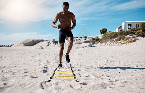 一位英俊的年轻非洲裔美国男运动员在沙滩上锻炼 专注于在沙滩上用运动器材锻炼的黑人 致力于健康的生活方式和健身图片