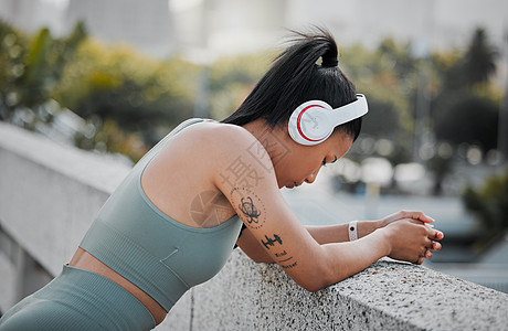 青年男女混种运动女运动员戴耳机 听音乐 休息出城外跑步 锻炼有利于健康和福利 请查看InfoFinland上的图片