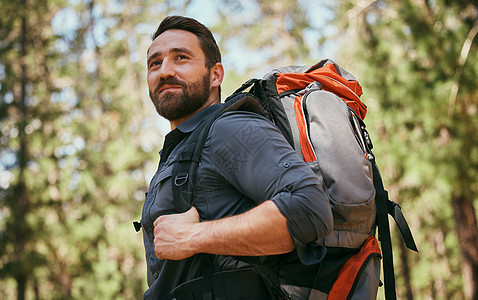 一个快乐的成年白人男子背着背包 白天独自在树林里徒步旅行 健康活跃的男性在独自探索大自然之美的同时享受徒步 锻炼和冒险图片
