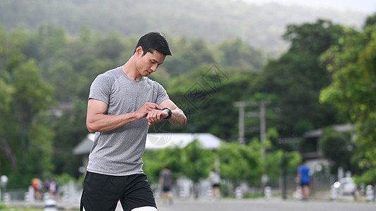 运动健壮的亚洲人休息和检查他的心率数据 在早上锻炼时在智能观察上图片