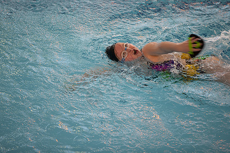 游泳池里戴着泳帽和泳镜的女孩 孩子参加的是游泳课图片
