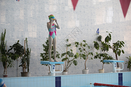 穿着泳衣的女孩和运动池里的游泳帽女士活动水池运动员游泳池活力游泳镜蓝色游泳者闲暇图片