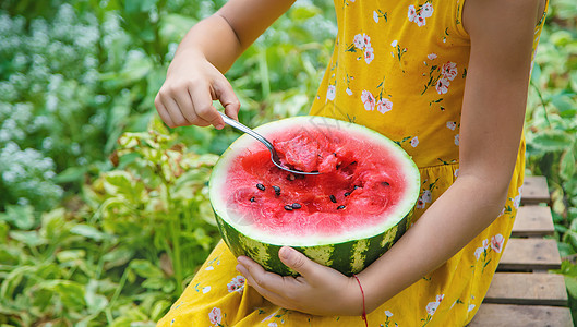 孩子用勺子吃西瓜 有选择的焦点女性食物童年帽子桌子幸福微笑女孩蔬菜快乐图片