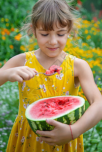 孩子用勺子吃西瓜 有选择的焦点蔬菜水果快乐女性帽子甜点童年婴儿微笑食物图片