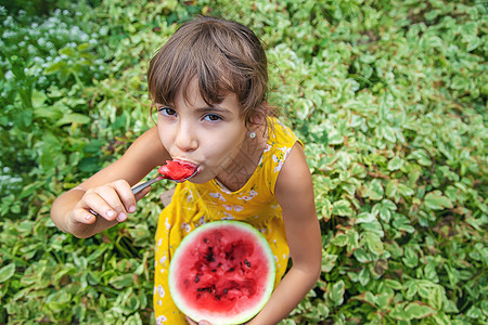 孩子用勺子吃西瓜 有选择的焦点小吃微笑食物帽子童年乐趣女孩快乐蔬菜水果图片
