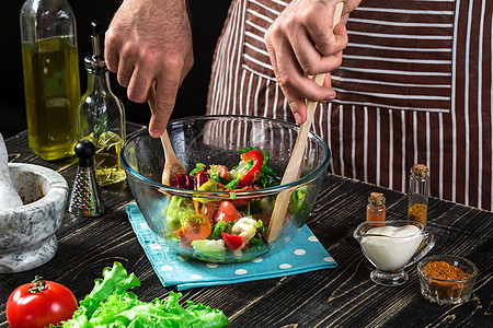 男人在木制桌上准备沙拉和新鲜蔬菜 烹饪美味而健康的食物厨房菠菜木板黄瓜饮食午餐厨师勺子胡椒盘子图片