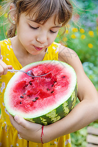 孩子用勺子吃西瓜 有选择的焦点女孩童年帽子桌子食物甜点小吃婴儿微笑营养图片