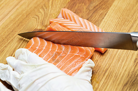 厨师用刀割红鱼 在木板上切了一条红鱼鱼片桌子饮食寿司食物厨房餐厅橙子盘子木头图片