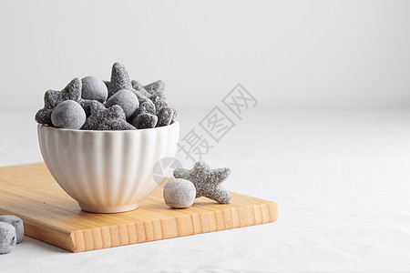 芬兰语 装在白碗和木板上桌子糖果氯化物黑色铵盐食物图片